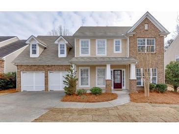 Charming two-story home featuring a two-car garage, brick accents and a welcoming front porch at 2341 Walnut Tree Ct, Buford, GA 30519