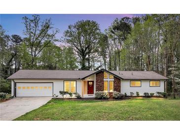 Charming one-story home with a two-car garage, a red door, and a manicured lawn at 3046 Wendgate Dr, Marietta, GA 30062