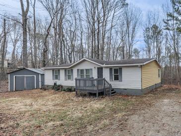 Charming single-story home featuring a simple front porch and shed, nestled amongst bare trees in winter at 1010 Martin Ln, Canton, GA 30114