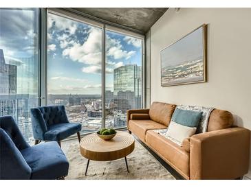 Bright living room featuring comfortable seating and floor-to-ceiling windows with stunning city views at 3324 Peachtree Ne Rd # 2118, Atlanta, GA 30326