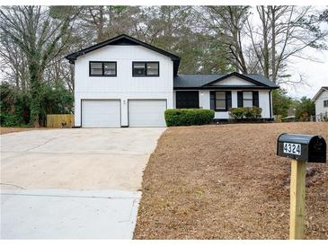 Charming two-story home with white siding, black trim, and a spacious two-car garage at 4324 Rue Saint Michel, Stone Mountain, GA 30083