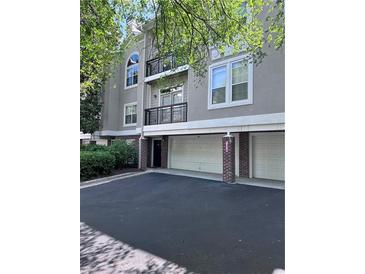 Attractive condo building featuring a private garage and welcoming curb appeal at 4244 River Green Nw Dr # 111, Atlanta, GA 30327