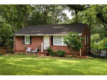 Charming brick home with a well-manicured lawn, cozy front porch and mature trees at 2413 Hillside Ave, Decatur, GA 30032