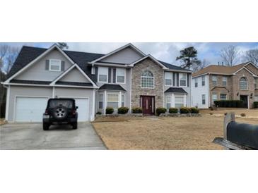 Beautiful two-story house with an attached two car garage and a stone facade entryway in a neighborhood setting at 2453 Wall Se St, Conyers, GA 30013