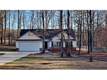 Charming single-story home featuring an attached garage and beautiful landscaping at 285 Belmont Trl, Covington, GA 30016