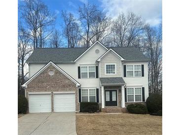 Charming two-story home with a brick facade, attached two-car garage, and well-maintained landscaping at 3305 Wickum Sw Rd, Atlanta, GA 30349