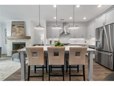 Modern kitchen with stainless steel appliances, gray cabinets, and center island with barstool seating at 2380 Edgar Park Pl # 101, Duluth, GA 30096