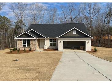 Charming single-story home featuring brick and stone accents, complemented by an attached two car garage at 3382 Milan Ct, Douglasville, GA 30135