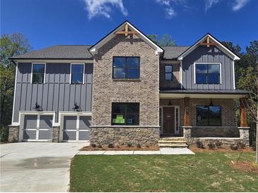 New two-story home with gray siding, stone accents, covered porch, and two-car garage at 3687 Thornhill Ct, Douglasville, GA 30135