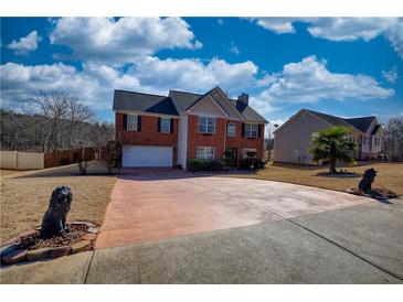 Charming two-story brick home with a spacious driveway, manicured lawn and beautiful landscaping at 120 Sunflower Ln, Covington, GA 30016