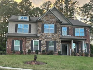 Beautiful two-story brick home with stone accents, a covered front porch, and manicured lawn at 2304 Northglenn Ct, Conyers, GA 30013