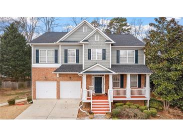Charming two-story home with brick and gray siding, a welcoming front porch, and a well-manicured lawn, perfect for curb appeal at 1657 Stilesboro Ridge Dr, Kennesaw, GA 30152