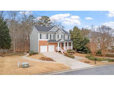 Inviting two-story home with a brick and gray facade, a well-manicured lawn, and an attached two-car garage at 1657 Stilesboro Ridge Dr, Kennesaw, GA 30152