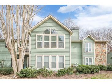 Charming two-story home with green siding, large windows, and well-maintained landscaping at 3205 Canyon Point Cir, Roswell, GA 30076