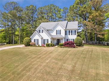 Charming two-story home featuring a well-manicured lawn and traditional architectural details at 4265 Elmhurst Ln, Cumming, GA 30028