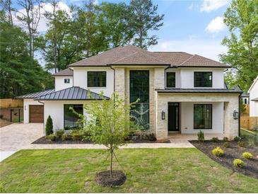 Stunning two-story home with a white exterior, stone accents, and lush landscaping, offering curb appeal at 401 Lynne Cir, Alpharetta, GA 30009