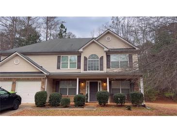 Charming two-story home with a covered front porch and well-maintained landscaping at 204 Hightower Trl, Riverdale, GA 30274