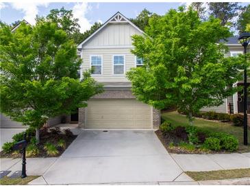 Charming townhouse showcasing a 2-car garage, lush landscaping, and a well-maintained lawn at 5433 Cascade Sw Rdg, Atlanta, GA 30336