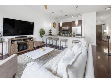 Bright living room features hardwood floors, modern furnishings and an open-concept layout to the kitchen at 200 N Highland Ne Ave # 207, Atlanta, GA 30307