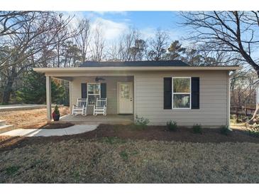 Charming exterior view of a single-story home featuring a cozy porch with rocking chairs at 100 Reed St, Canton, GA 30114