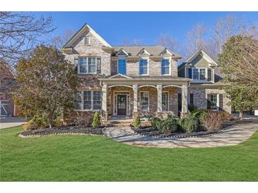 Beautiful two-story brick home with a manicured lawn and welcoming front porch at 4050 Preserve Crossing Ln, Cumming, GA 30040