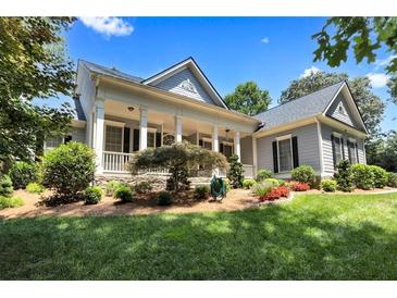 Charming home with a landscaped front yard and inviting covered porch with columns at 306 Blake Dr, Canton, GA 30114