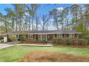 Charming brick home with mature trees, lush lawn and covered carport in a tranquil setting at 3063 Randolph Ne Rd, Atlanta, GA 30345