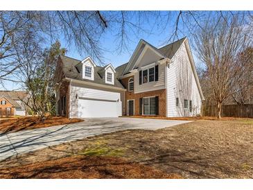 Charming two-story home featuring a brick and white exterior and well-maintained front yard at 3565 Mystic Dr, Buford, GA 30519