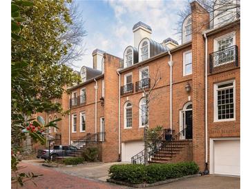 Charming brick townhomes featuring arched windows, small balconies, and well-maintained landscaping at 2600 Peachtree Nw Rd # 10, Atlanta, GA 30305