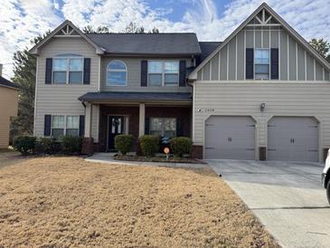 Charming two-story home featuring a two-car garage, well-maintained lawn, and classic architectural details at 3429 Lake End Dr, Loganville, GA 30052