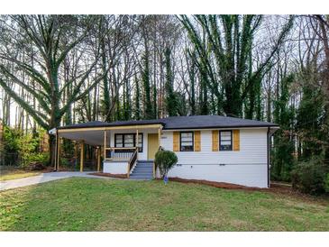 Charming single-story home featuring a covered porch and freshly painted exterior with decorative window shutters at 2895 Akron St, Atlanta, GA 30344
