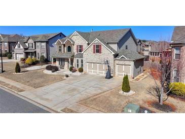Traditional two-story brick home with attached two-car garage and long driveway at 3488 In Bloom Way, Auburn, GA 30011