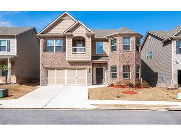 Two-story brick home featuring an attached two car garage and well-manicured lawn at 1187 Kingston Hill Dr, Loganville, GA 30052