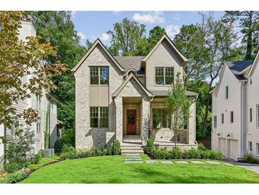 Charming two-story brick home with manicured lawn and inviting front entrance at 114 Terrace Ne Dr, Atlanta, GA 30305