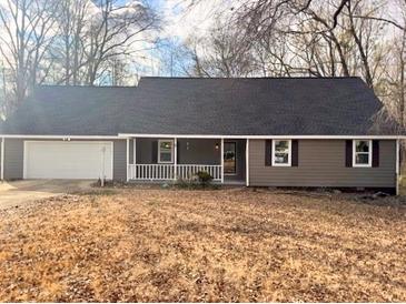 Charming single-story home with a covered porch, a two-car garage, and attractive neutral-toned siding at 25 Oak Crest Ct, Covington, GA 30016