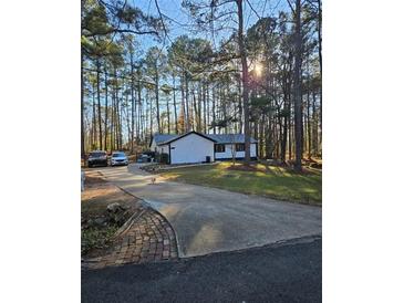 A sprawling home with a long driveway nestled among mature pine trees at 135 Windy Hill Rd, Fayetteville, GA 30214