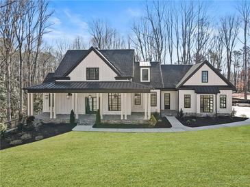 Stunning modern farmhouse with black trim, a covered porch, and a beautifully landscaped front yard at 7760 E Cherokee Dr, Canton, GA 30115