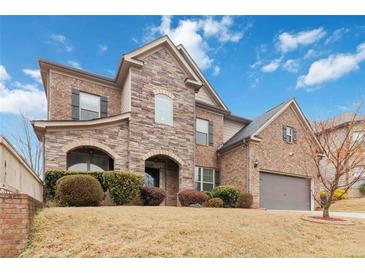 Charming two-story home featuring a stone and brick facade, arched entryway, and manicured landscaping at 4808 Albany Way, Atlanta, GA 30331