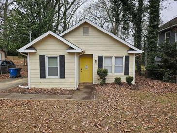 Charming single-story home with a yellow front door, black shutters, and a cozy landscaped front yard at 2921 8Th St, East Point, GA 30344