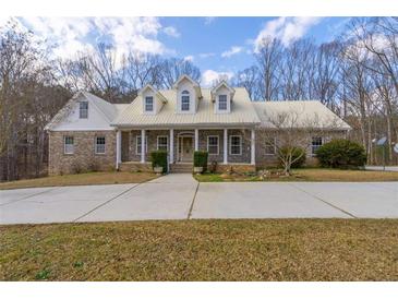 Beautiful brick home with a metal roof, dormer windows, and a large front yard at 550 Oak Ridge Dr, Oxford, GA 30054