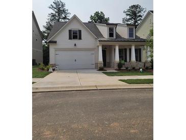Charming home boasts a two-car garage, inviting porch, and neutral color scheme at 866 Lakemont Dr, Canton, GA 30114