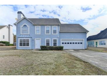 Two-story home with a blue facade, attached two-car garage and manicured front yard at 312 Jodeco Station E Cir, Stockbridge, GA 30281