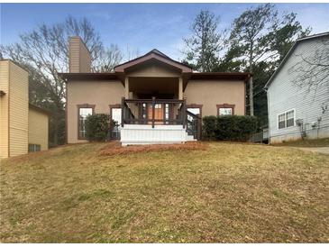 Inviting home with a charming front porch, stucco exterior, and well-maintained lawn at 4893 Hairston Pl, Stone Mountain, GA 30088