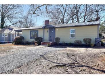 Charming single-story home with a tidy front yard, a metal roof, and a quaint covered entryway at 127 Holly St, Social Circle, GA 30025