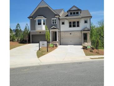 Charming townhome with gray and white facade, two-car garage and well manicured lawn at 203 Retreat Ln, Canton, GA 30114