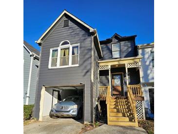 Charming two-story home featuring a covered porch and attached garage at 8056 S Bay Ct, Riverdale, GA 30274