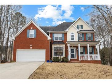 Charming two-story brick home featuring a two-car garage and inviting front porch at 130 Brookridge Ct, Fayetteville, GA 30215