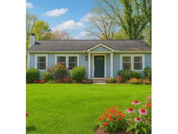 Charming single-story home features a lush green lawn and colorful flowerbeds, creating a welcoming curb appeal at 2184 Clairmont Ne Ter, Atlanta, GA 30345