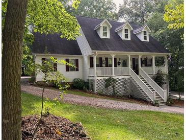 Charming two-story home featuring a welcoming front porch with dormer windows and landscaped surroundings at 525 S Lost Lake Cv, Villa Rica, GA 30180