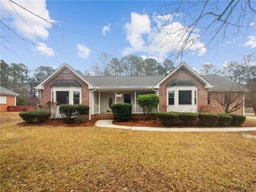 Charming brick home with well-manicured landscaping and inviting front porch at 180 Antebellum Way, Fayetteville, GA 30215
